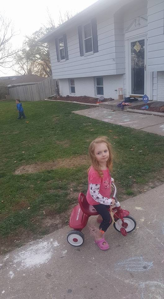Child on a tricycle on a sidewalk