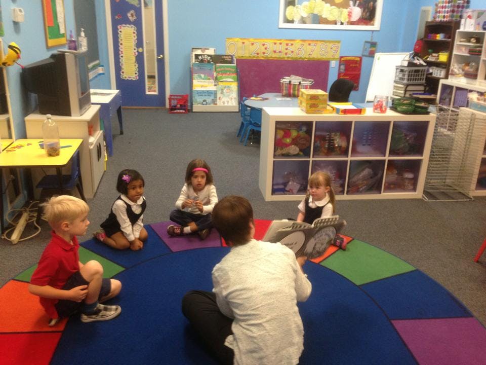 Adult and children sitting on floor in a classroom