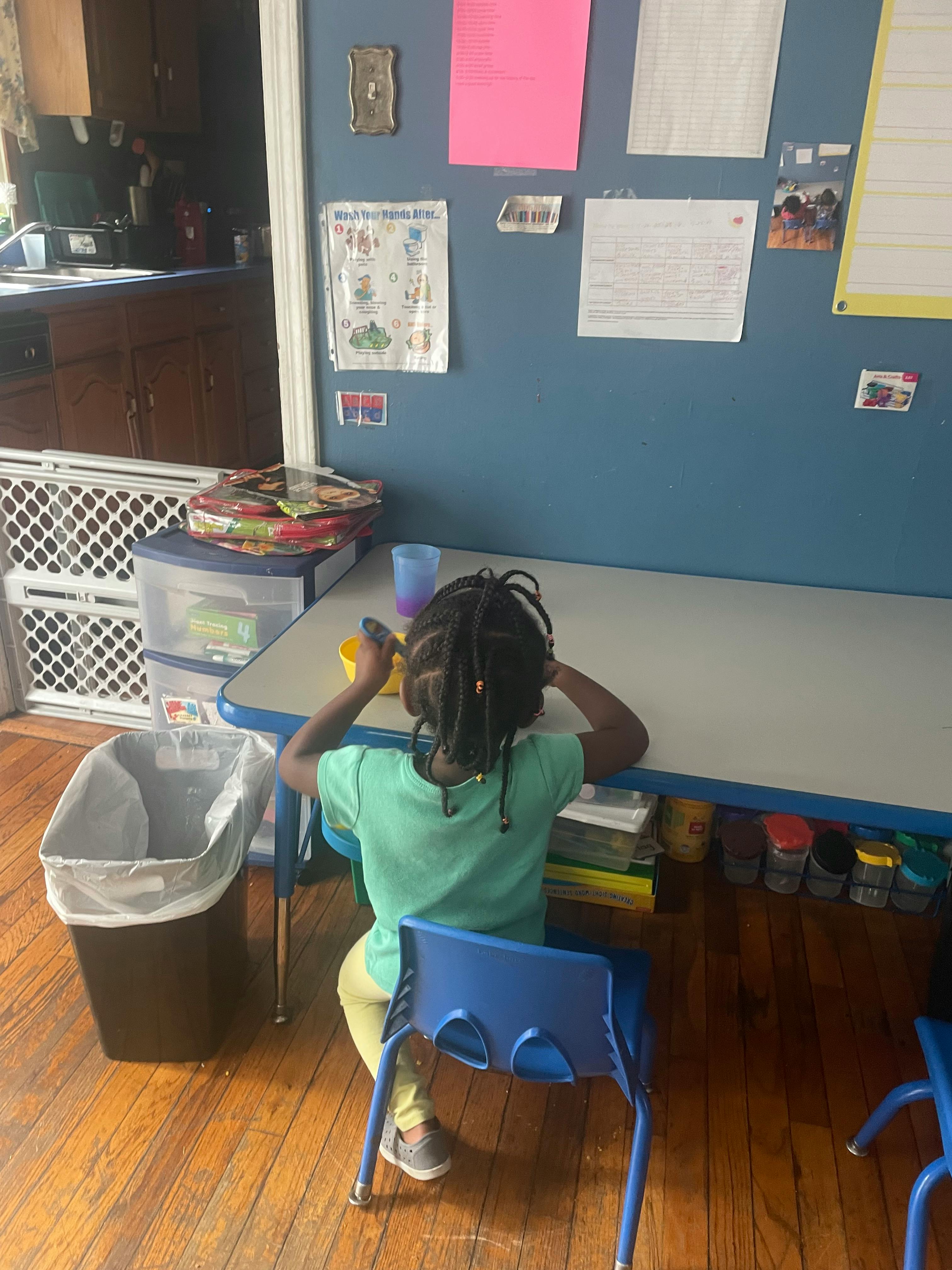 Child sitting at a table in a classroom