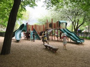 Children playing on a playground with slides and climbing structures