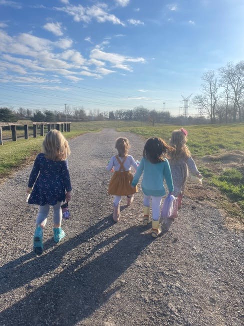 Four children walking away on a gravel path