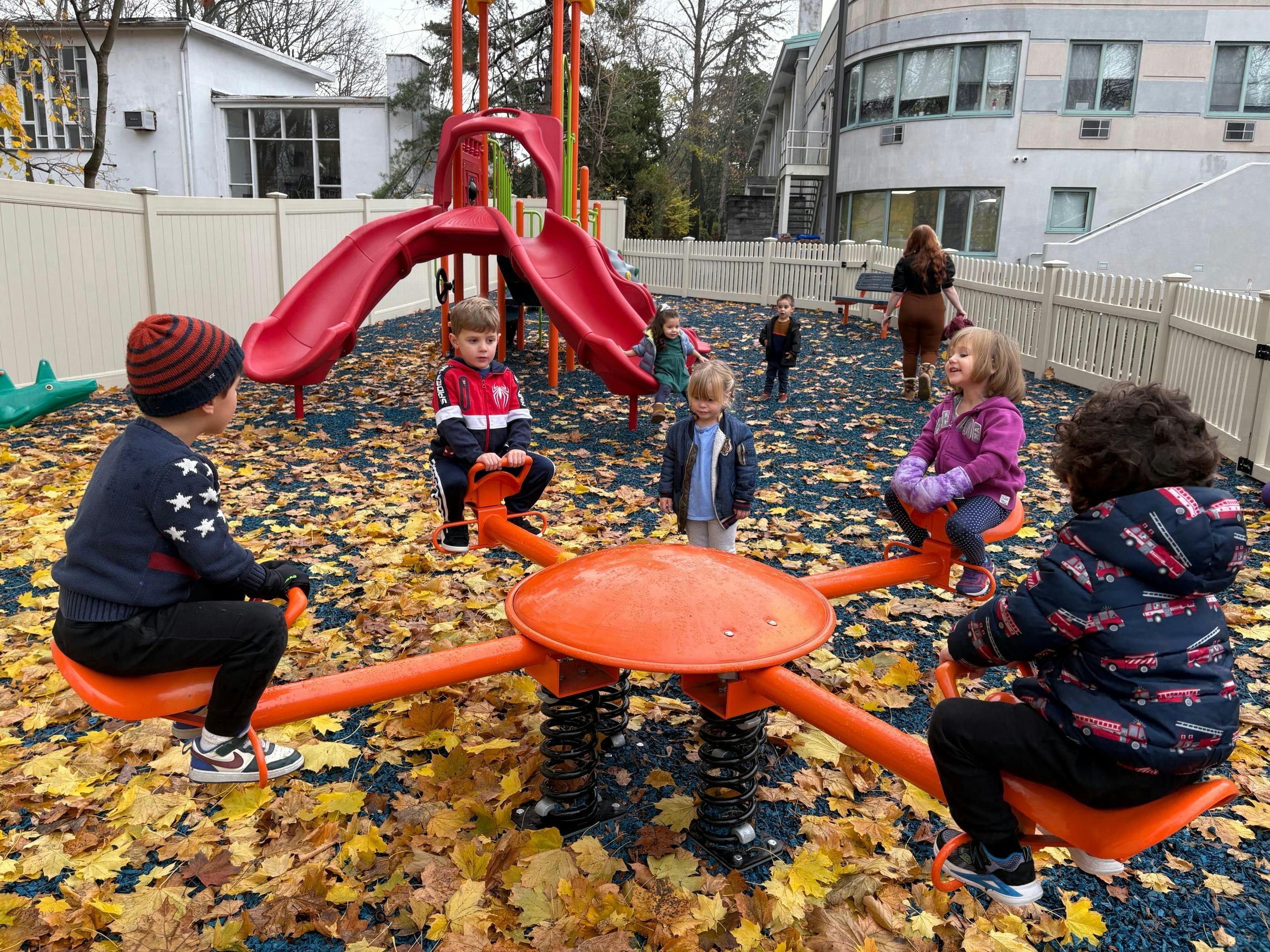 Children playing on a spring rider and slide on a playground