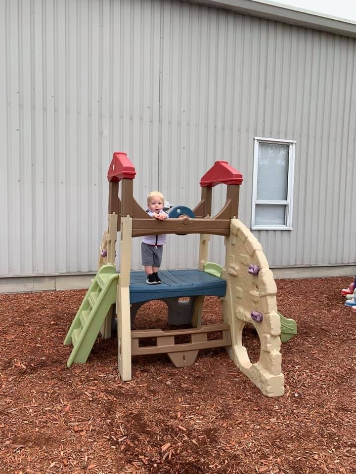 Child standing on a small playground structure
