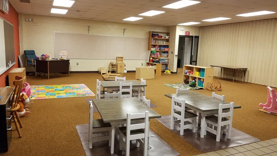 Empty classroom with small tables and chairs