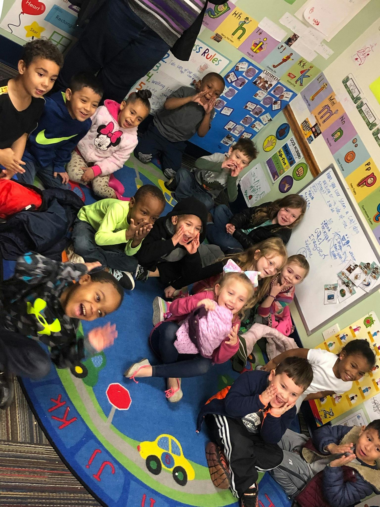Group of children sitting on a rug in a classroom