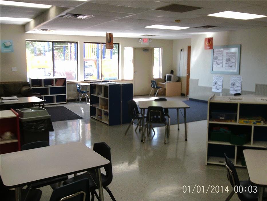 Empty classroom with tables, chairs, and shelves