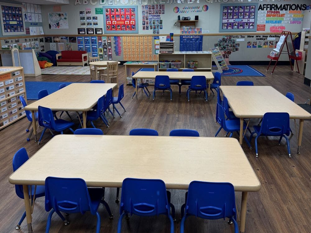 Classroom with multiple tables and blue chairs