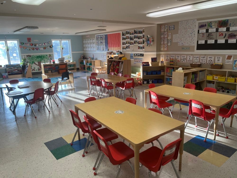 Empty classroom with tables and red chairs bathed in sunlight