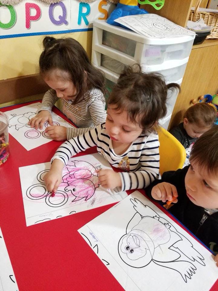 Children coloring at a table in a classroom