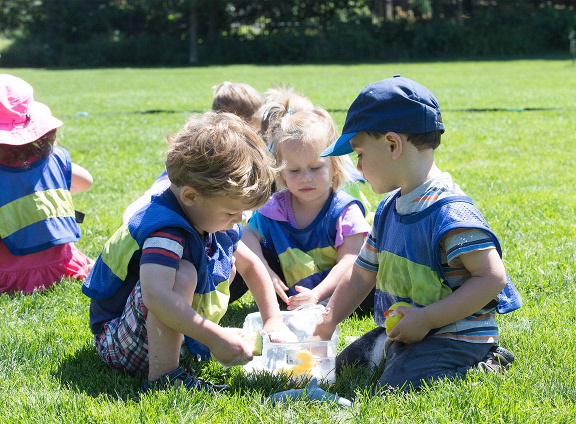 Children playing with a container on grass