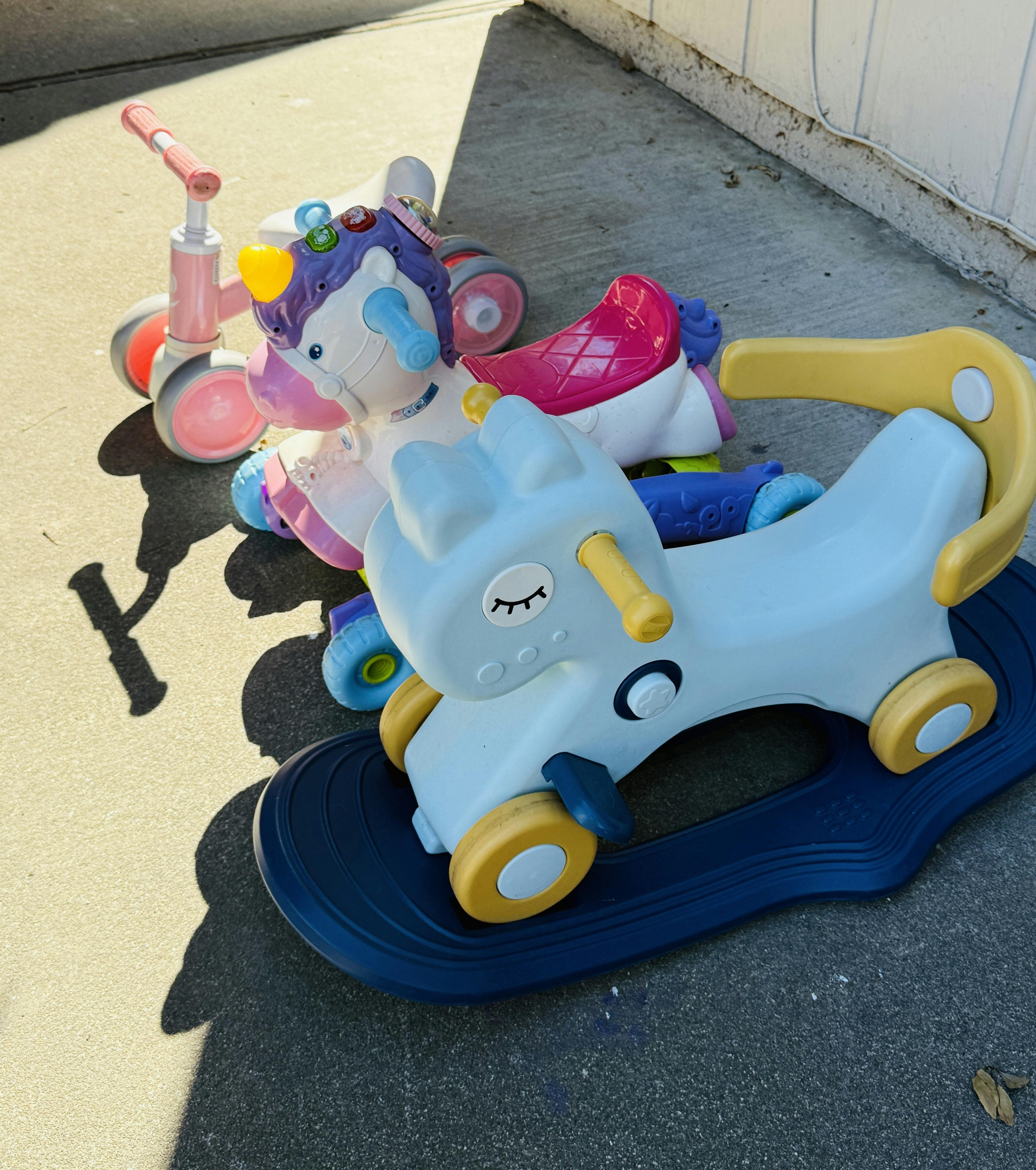 Children's ride-on toys, including a rocking horse and a scooter