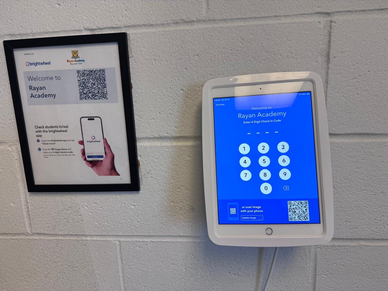 A framed sign next to a tablet displaying a check-in screen for Rayan Academy