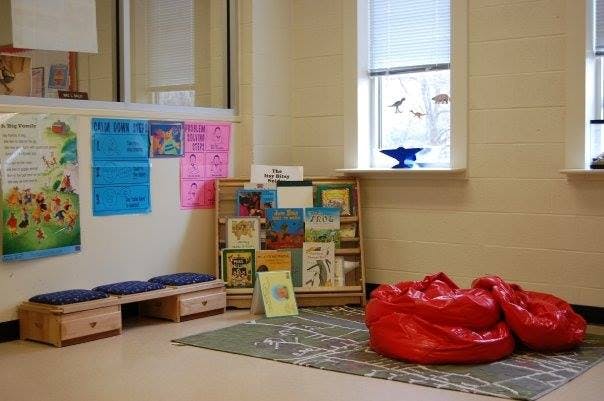 Reading nook with a bookshelf, bench, and red beanbag chairs