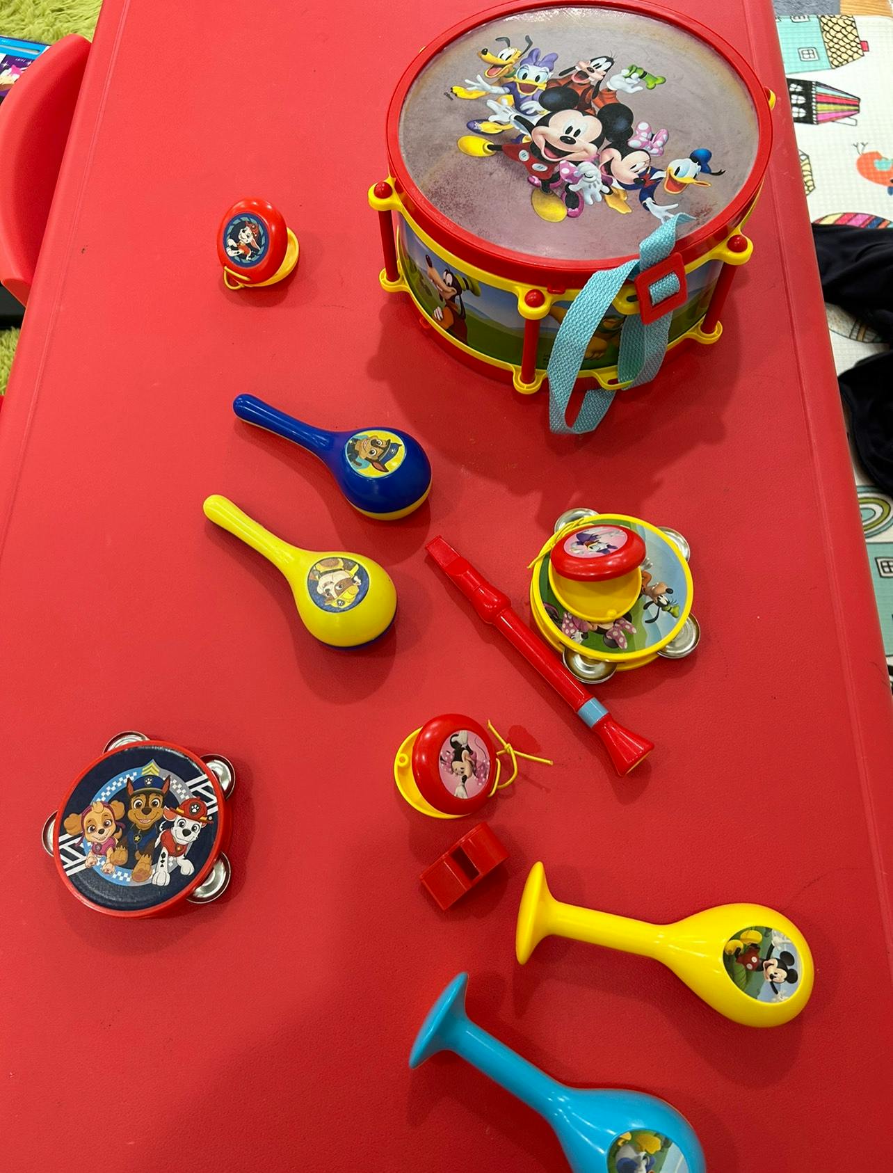 Children's musical instruments including a drum, maracas, and tambourines