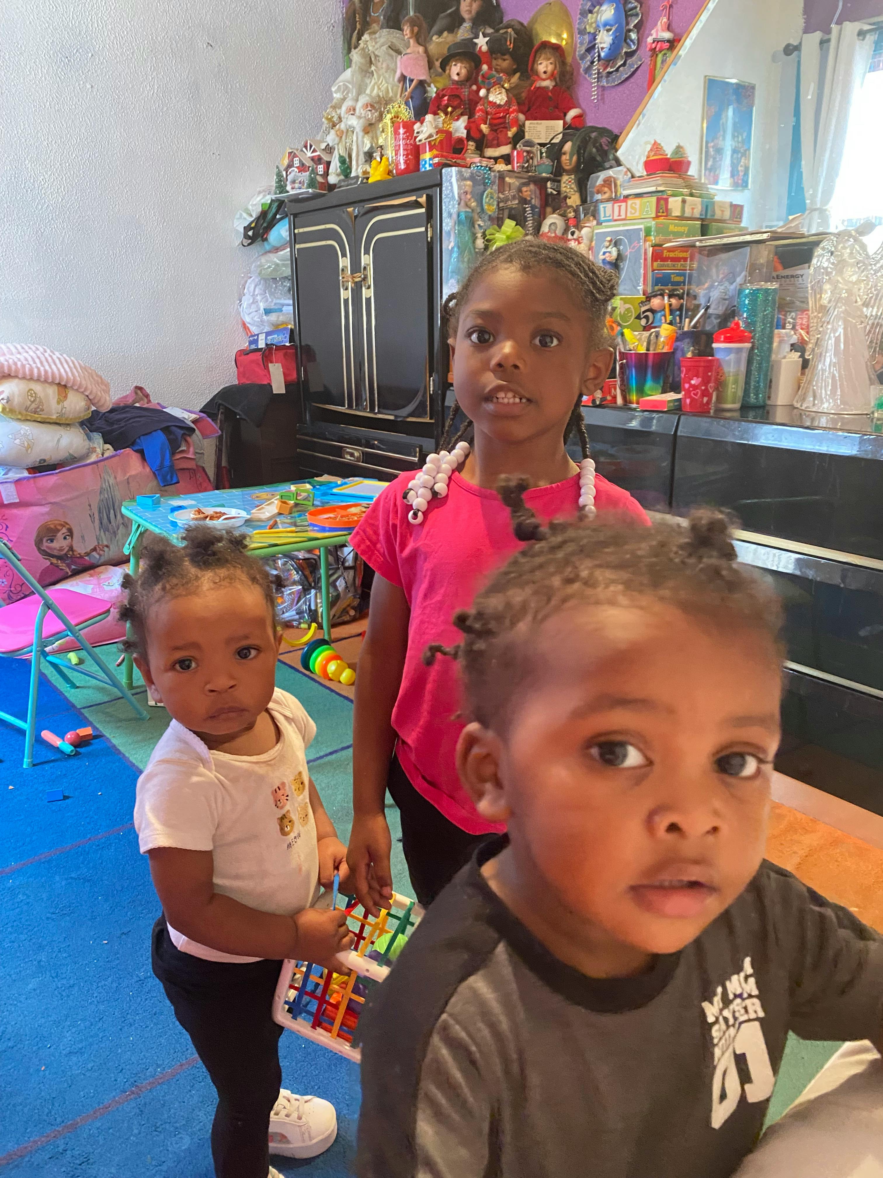 Three children standing indoors