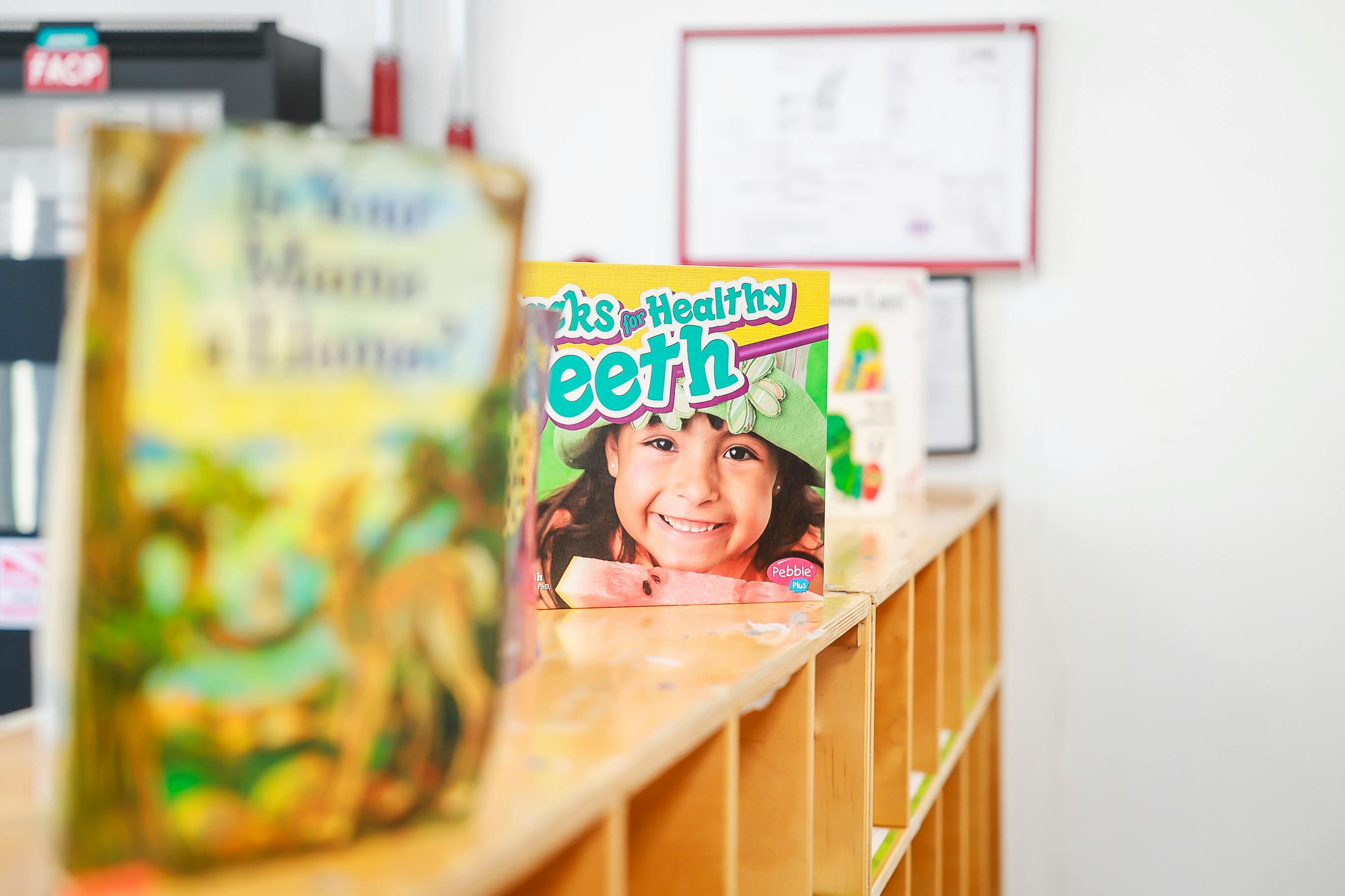 Book cover titled Snacks for Healthy Teeth on a wooden classroom shelf