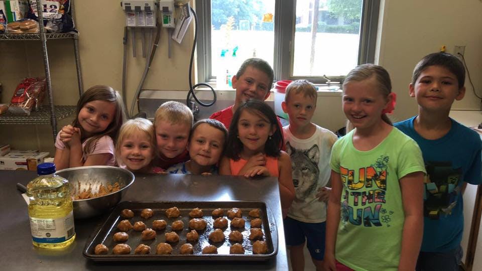 Group of children and teens with a tray of cookies