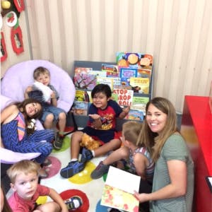 Adult and children sitting on floor in a classroom