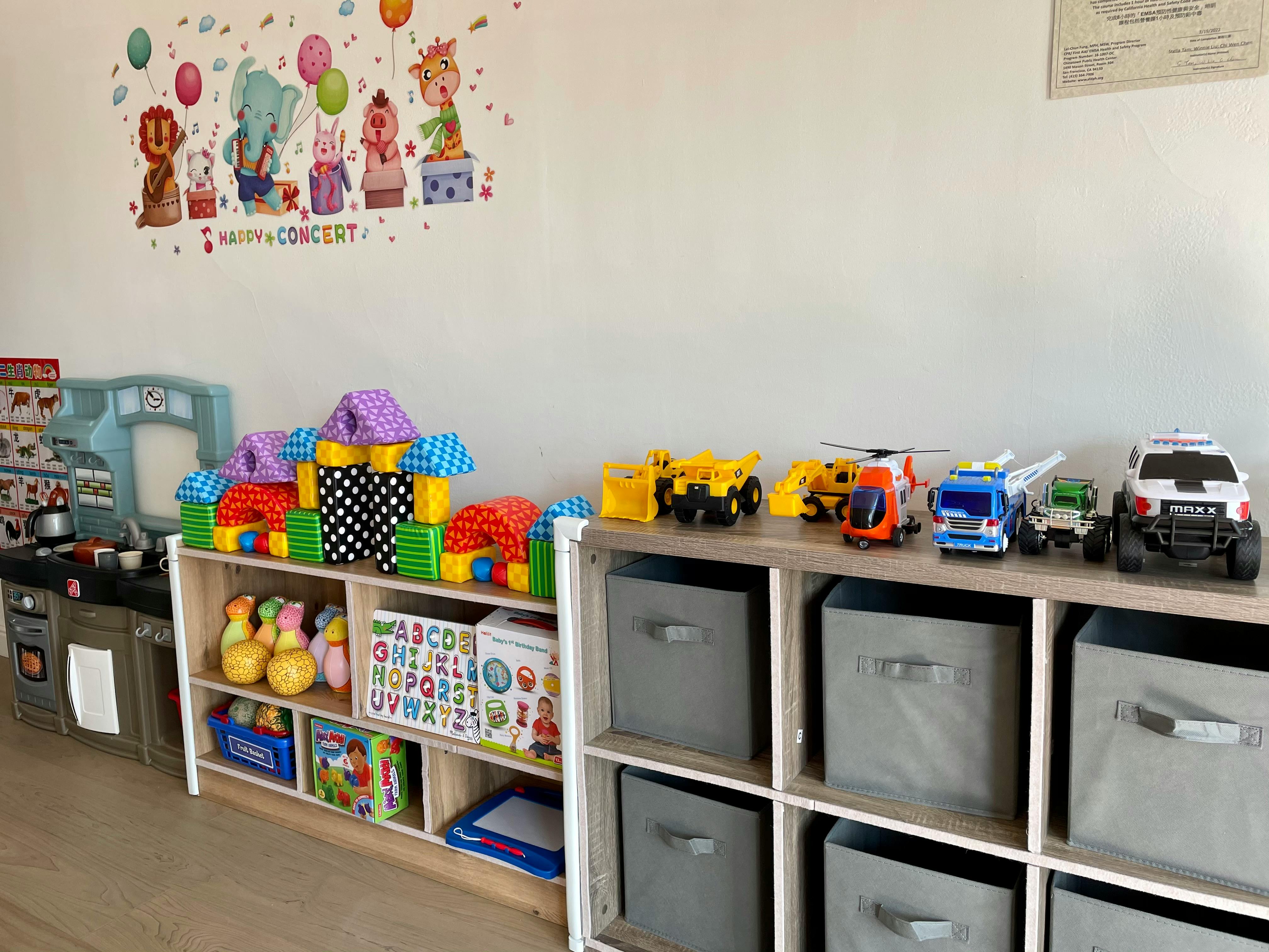 Shelves with toys, including blocks, trucks, and storage bins