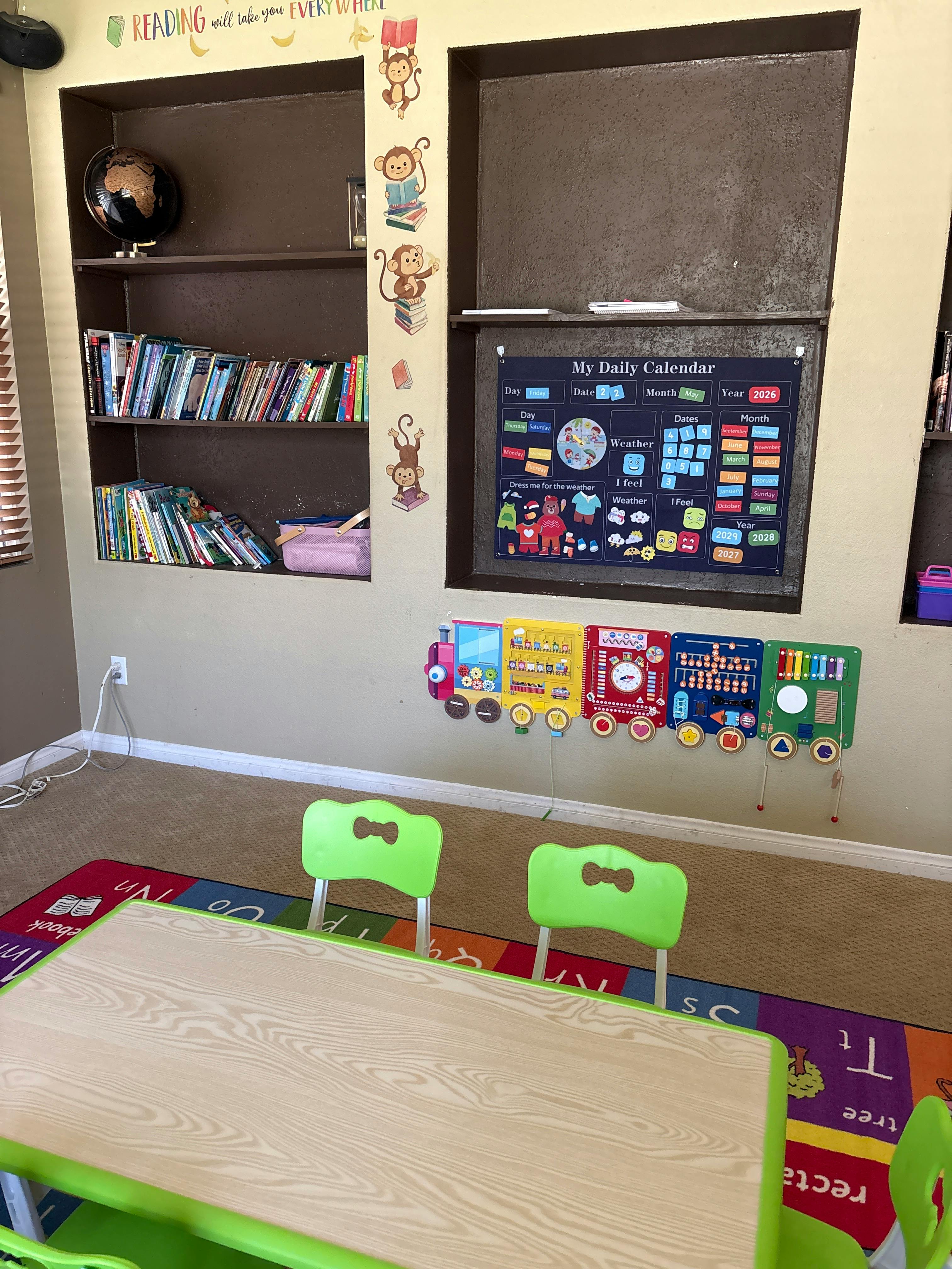 Classroom with a daily calendar chart, play activity boards, small table and chairs
