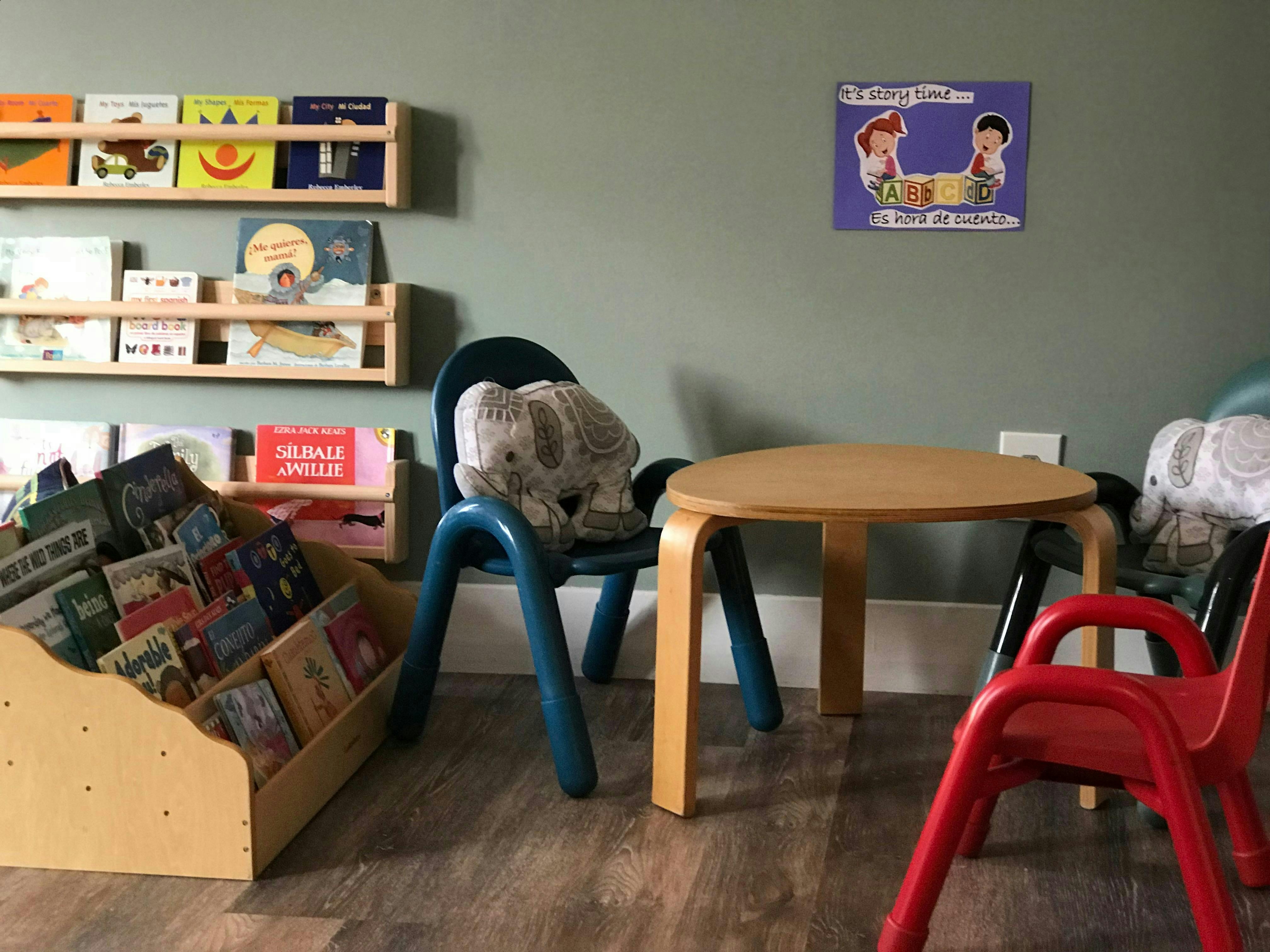Small table and chairs with children's books and shelves