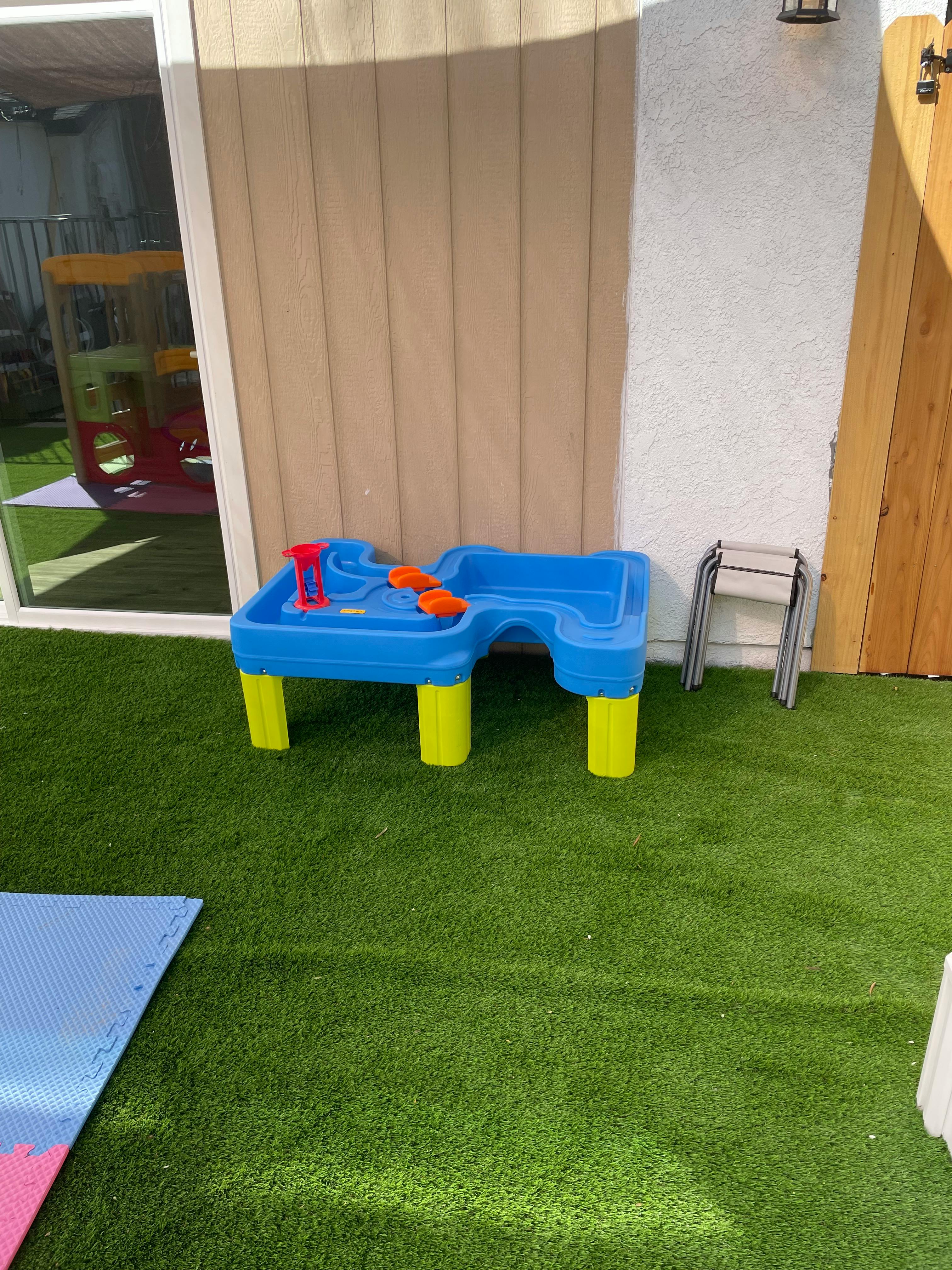 Blue and yellow water table on artificial grass