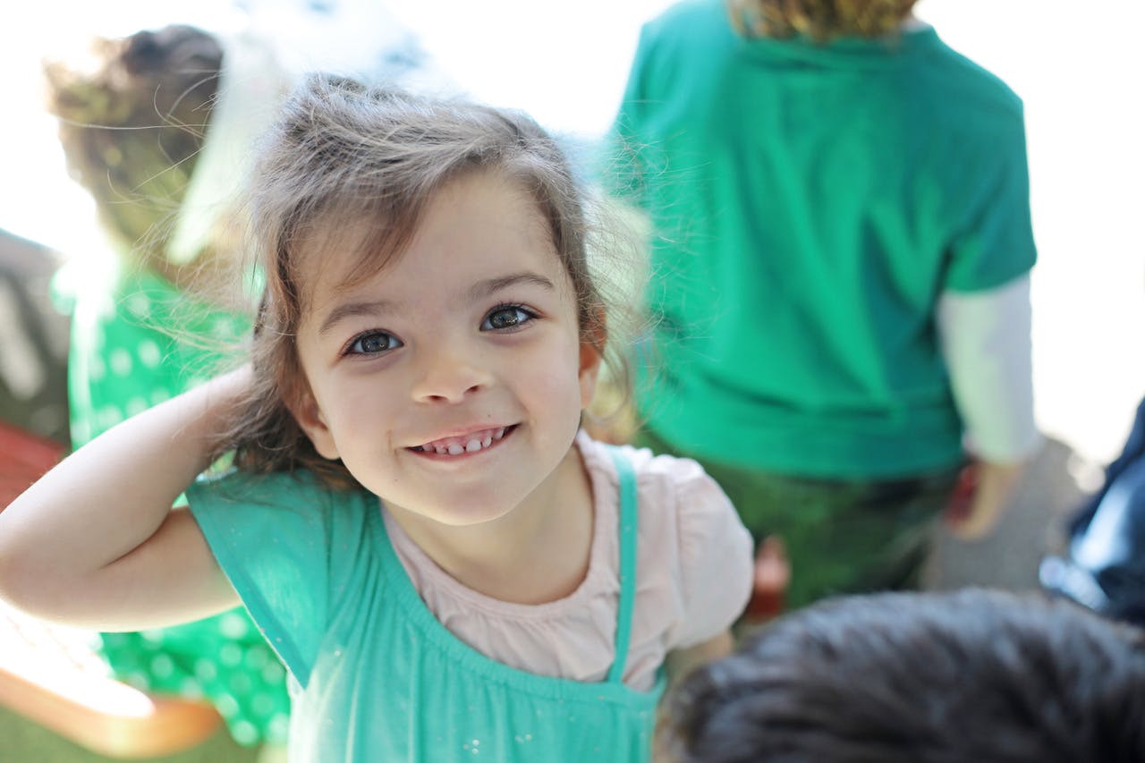 Child looking at camera with hand near head