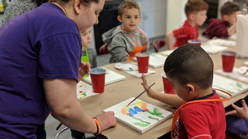 Adult and children painting at a table