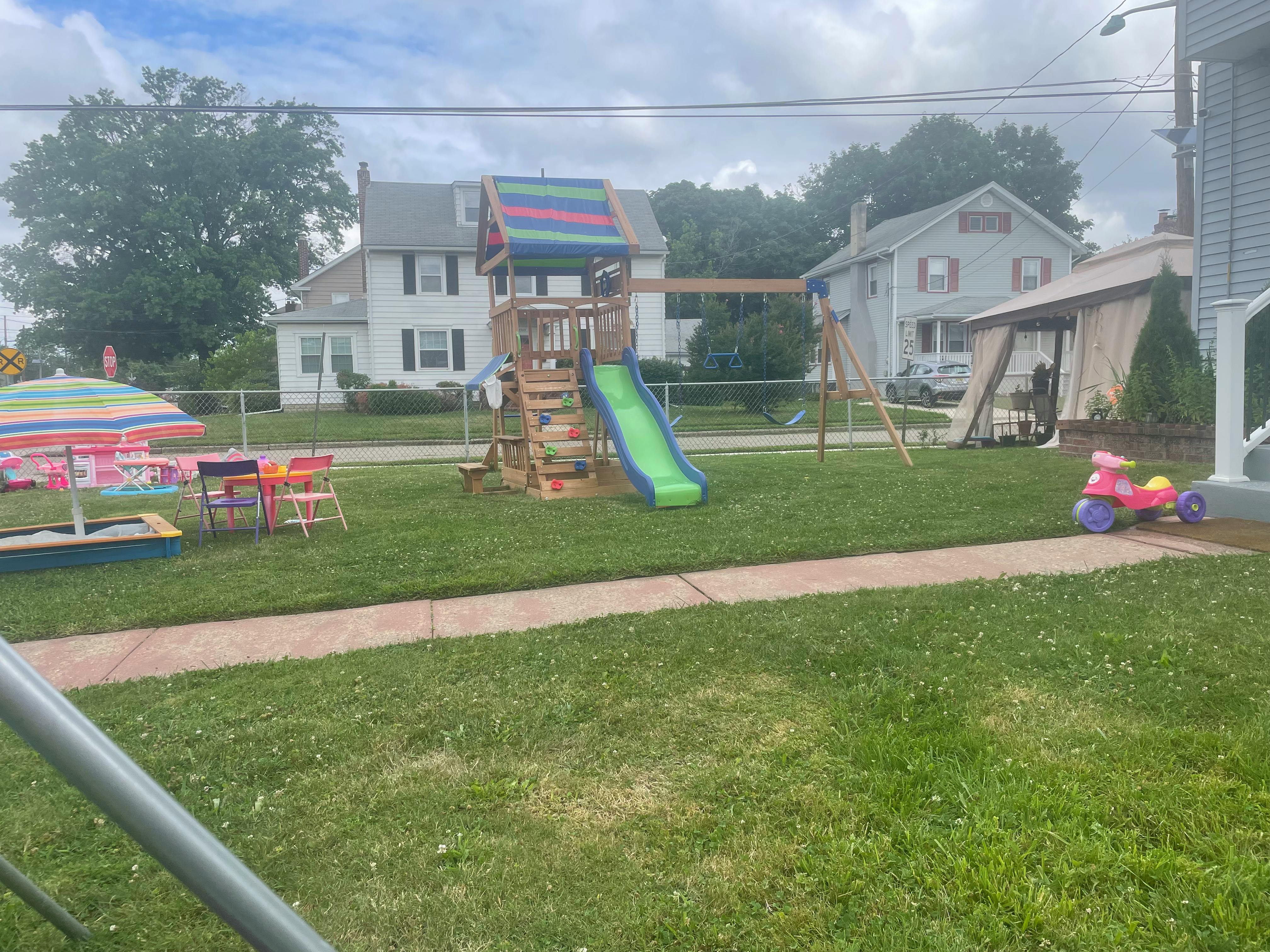Outdoor playground with a slide, swings, and a sandpit
