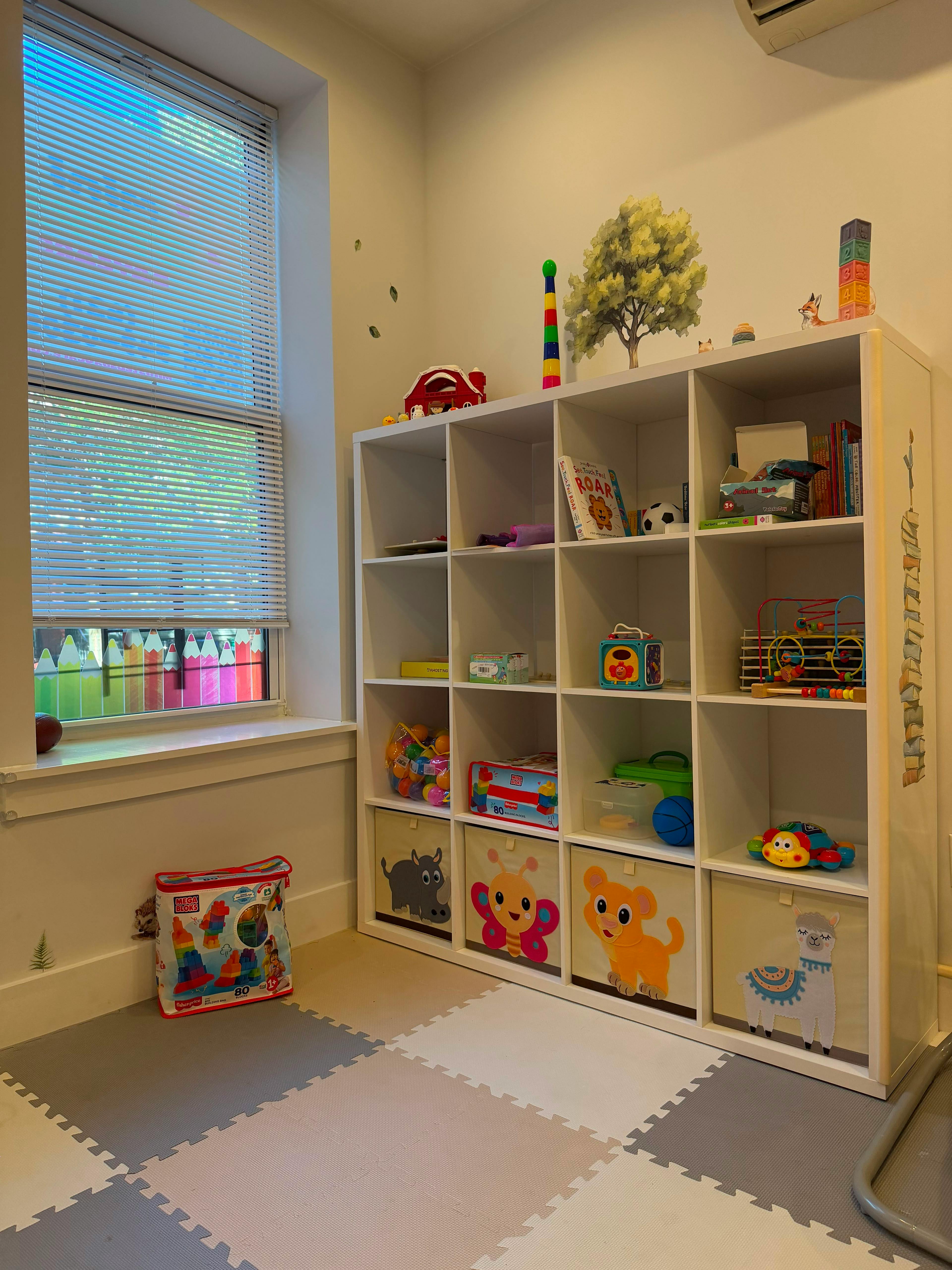 White storage shelf filled with children toys and animal themed storage bins