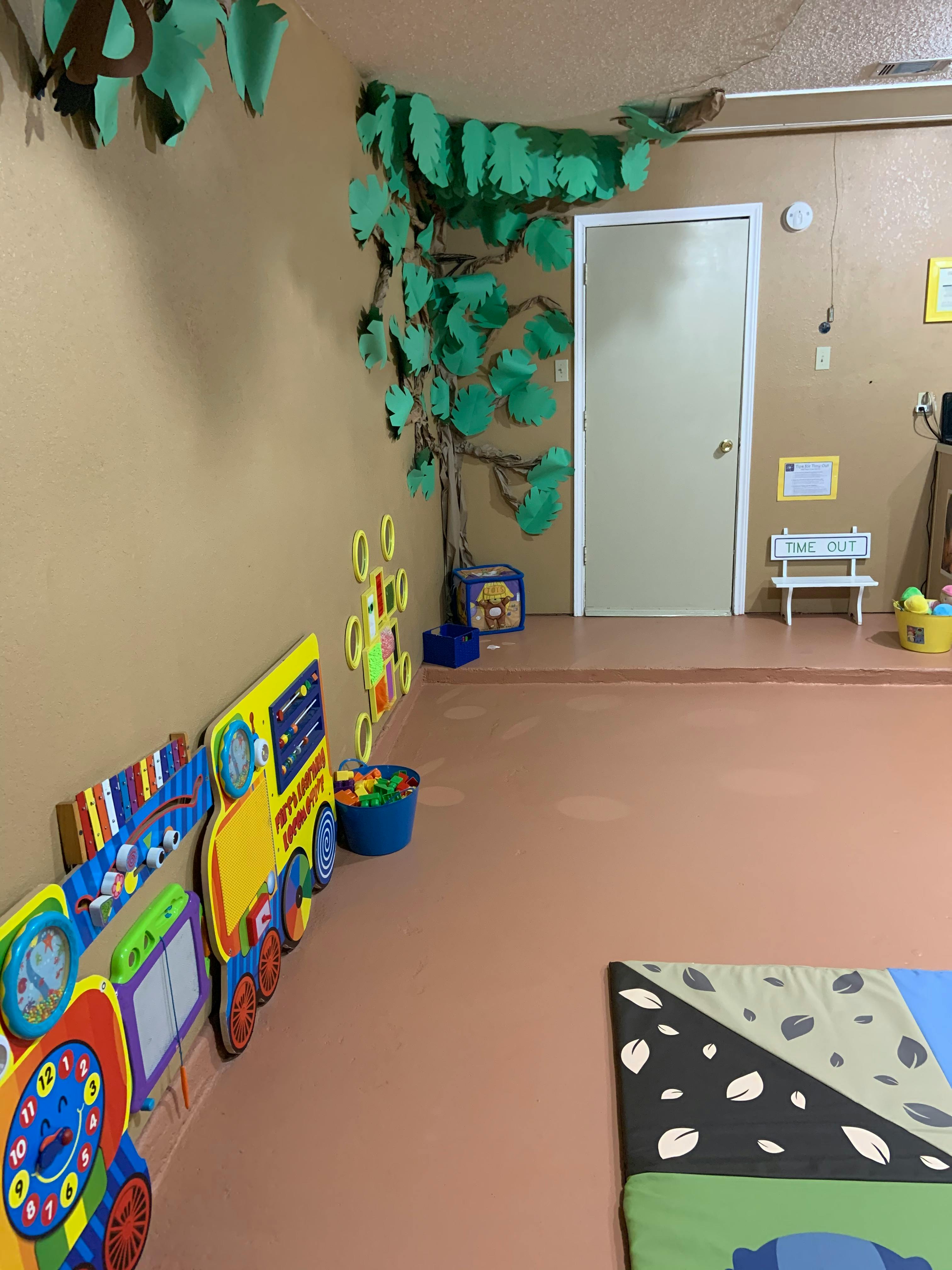 Playroom with wall decorations including a tree and train cutouts