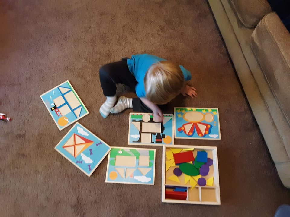 Child on floor playing with puzzles