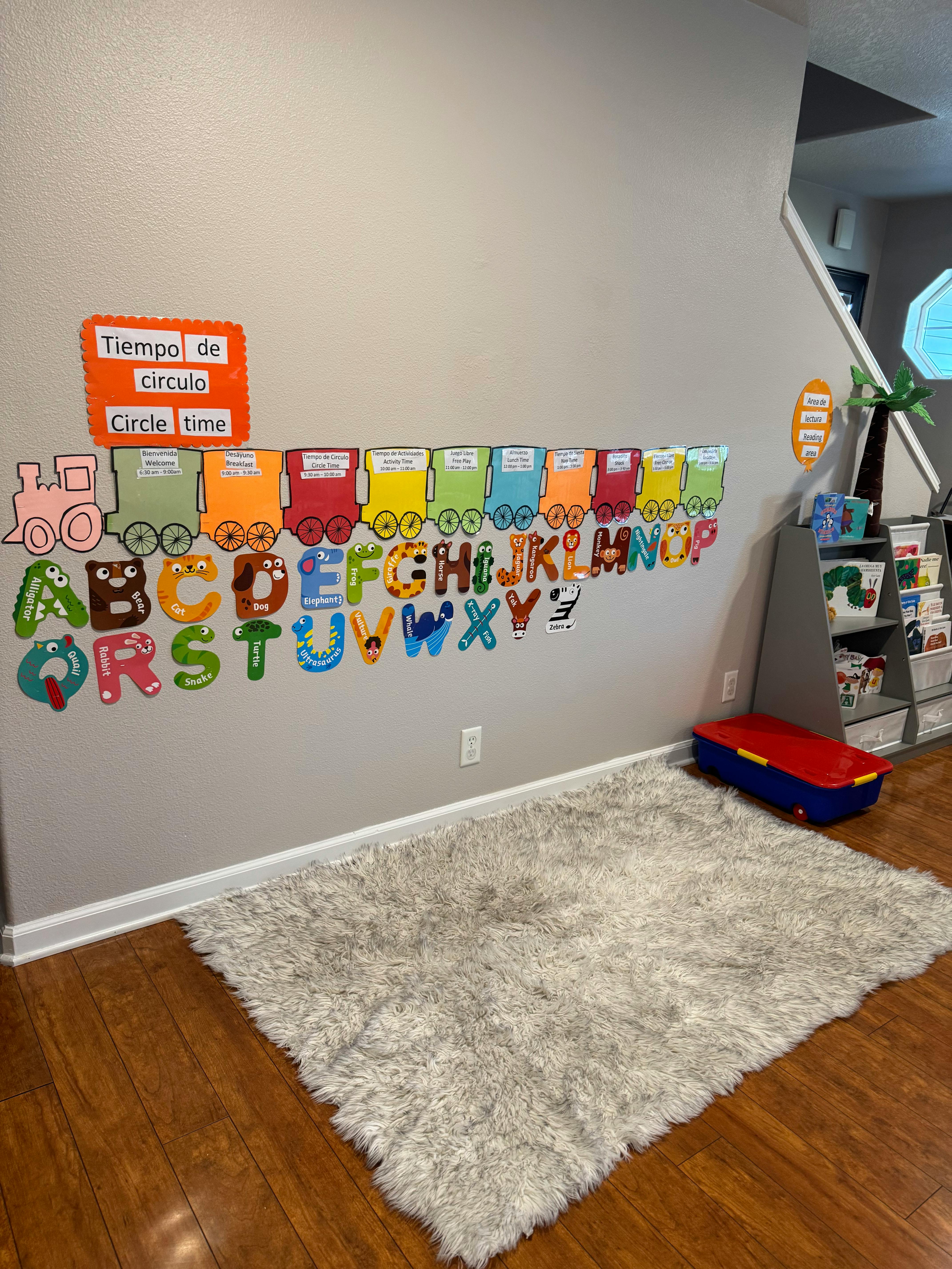 Wall with colorful alphabet letters and a train display, a rug on the floor