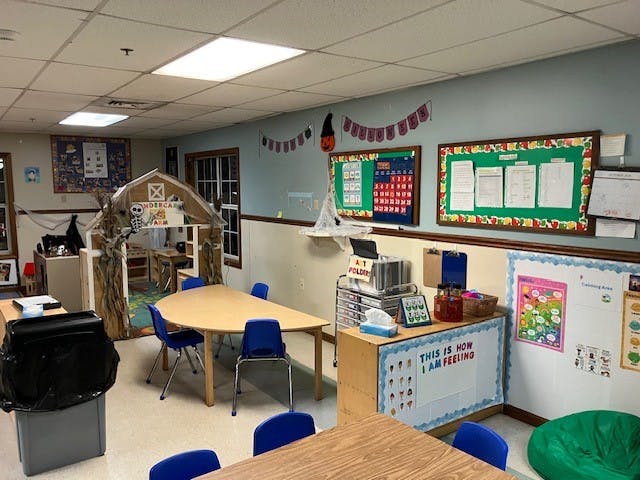 Classroom decorated for Halloween with tables, chairs, and bulletin boards