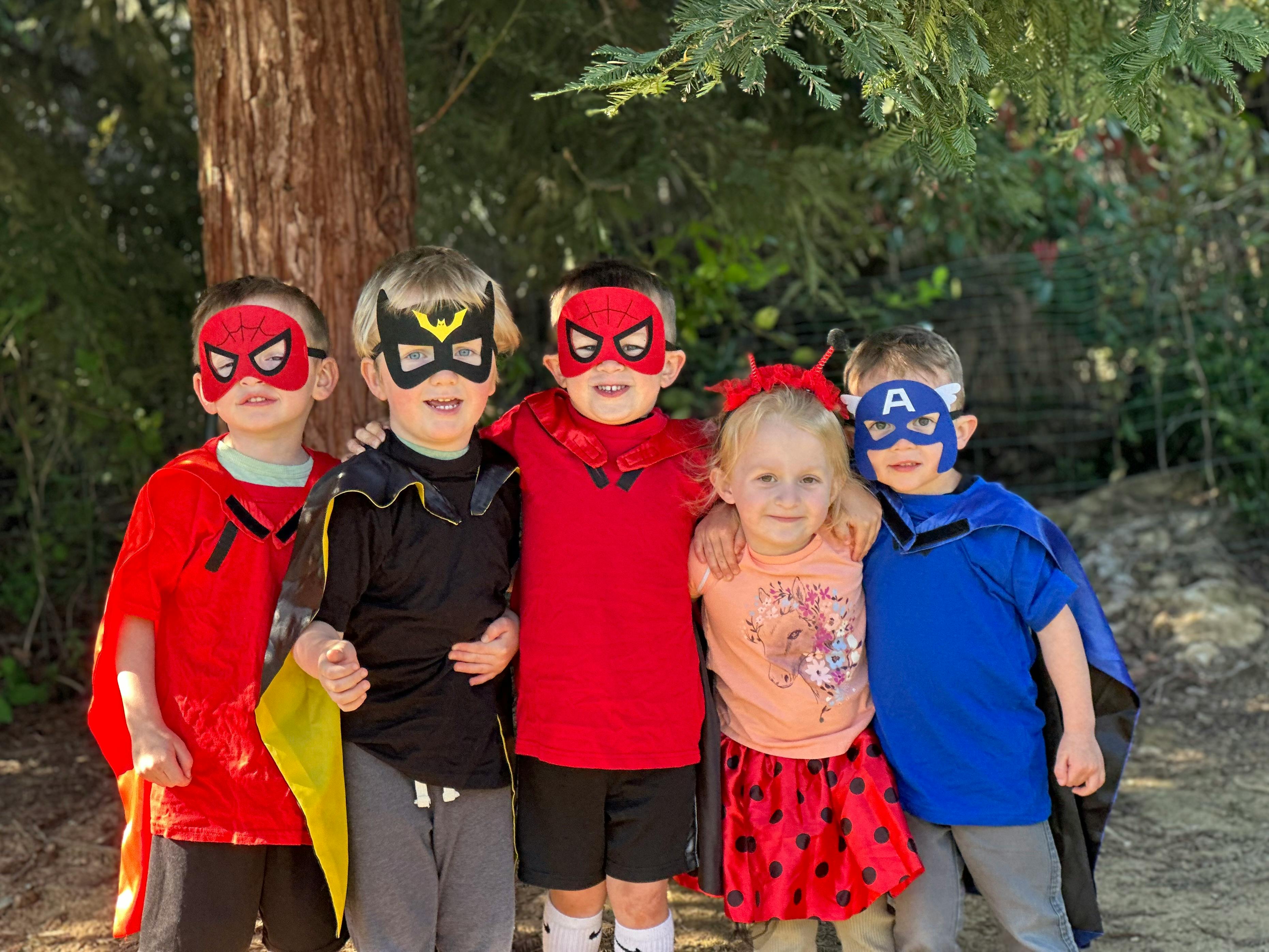 Five children in superhero costumes and masks