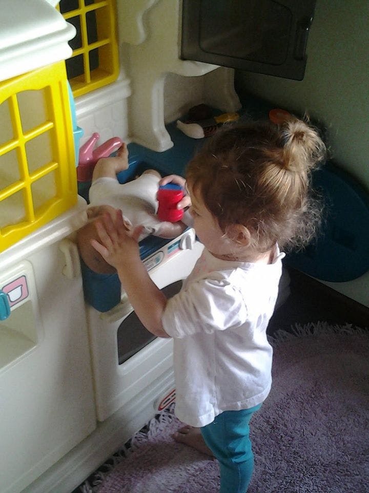 Child playing with a toy kitchen set
