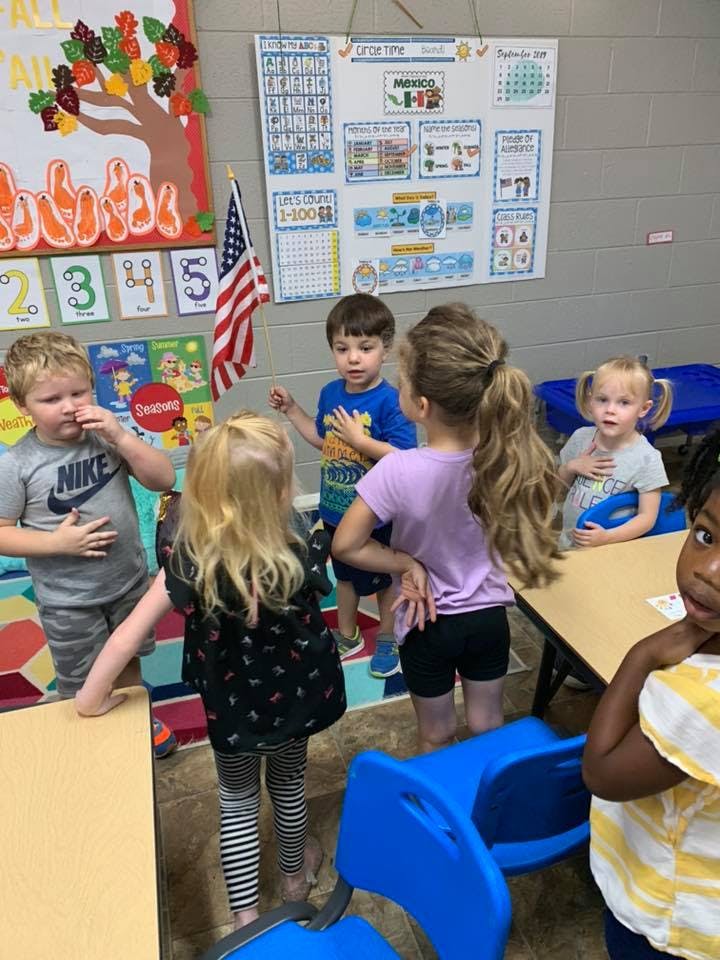Group of children standing in a classroom
