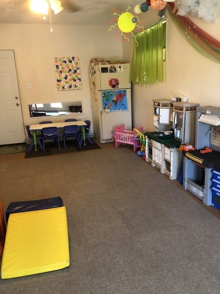 Playroom with small table and chairs, toy kitchen, and play tools