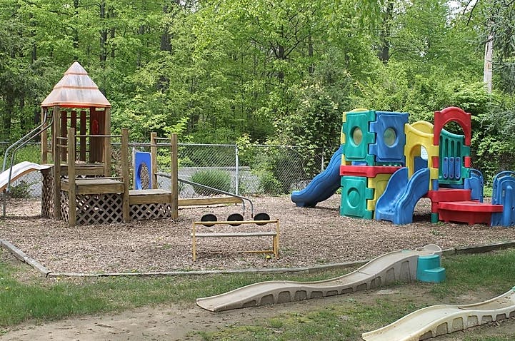 Outdoor playground with wooden structure and colorful plastic play equipment