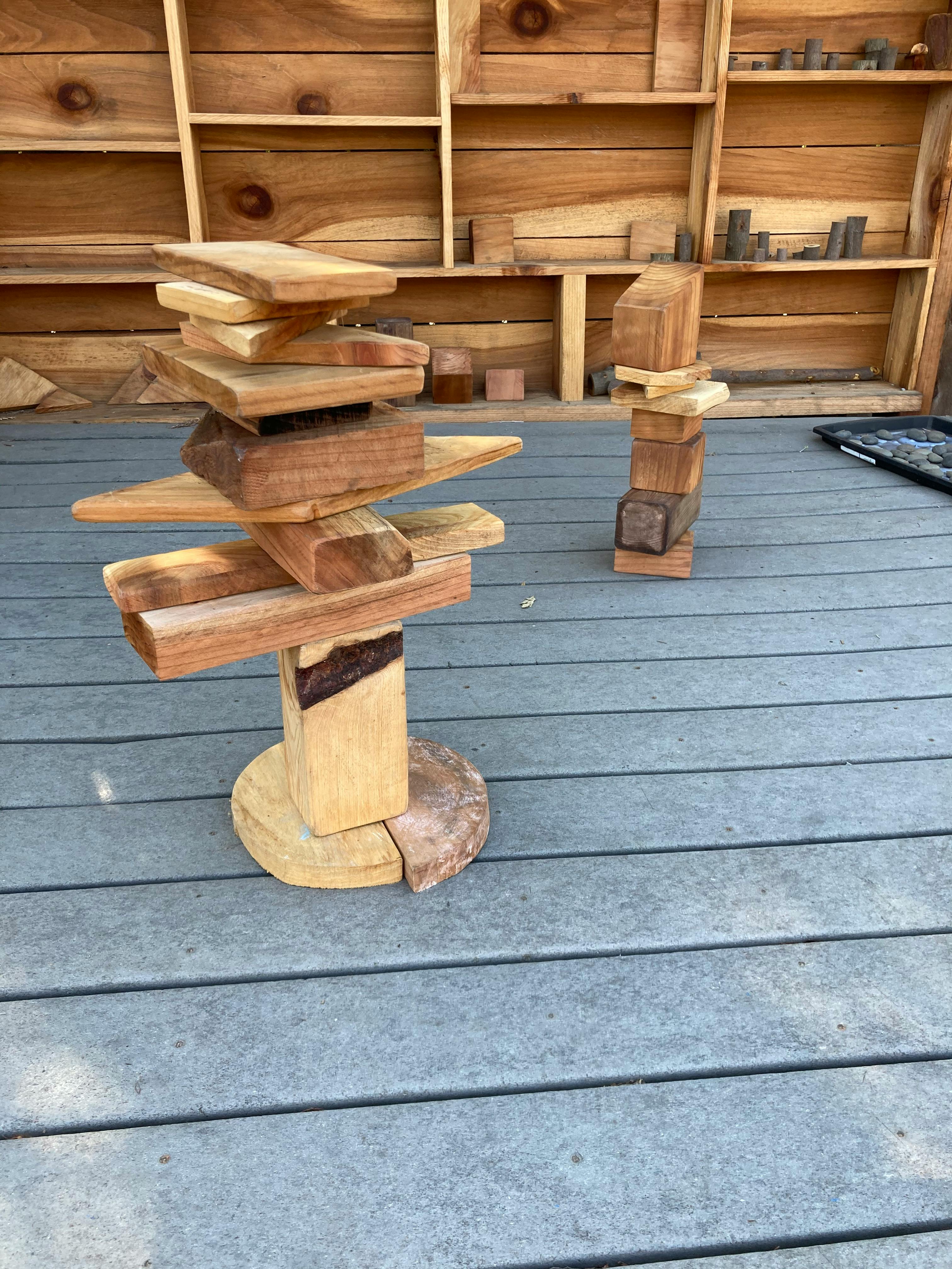 Two sculptures made of stacked wooden blocks