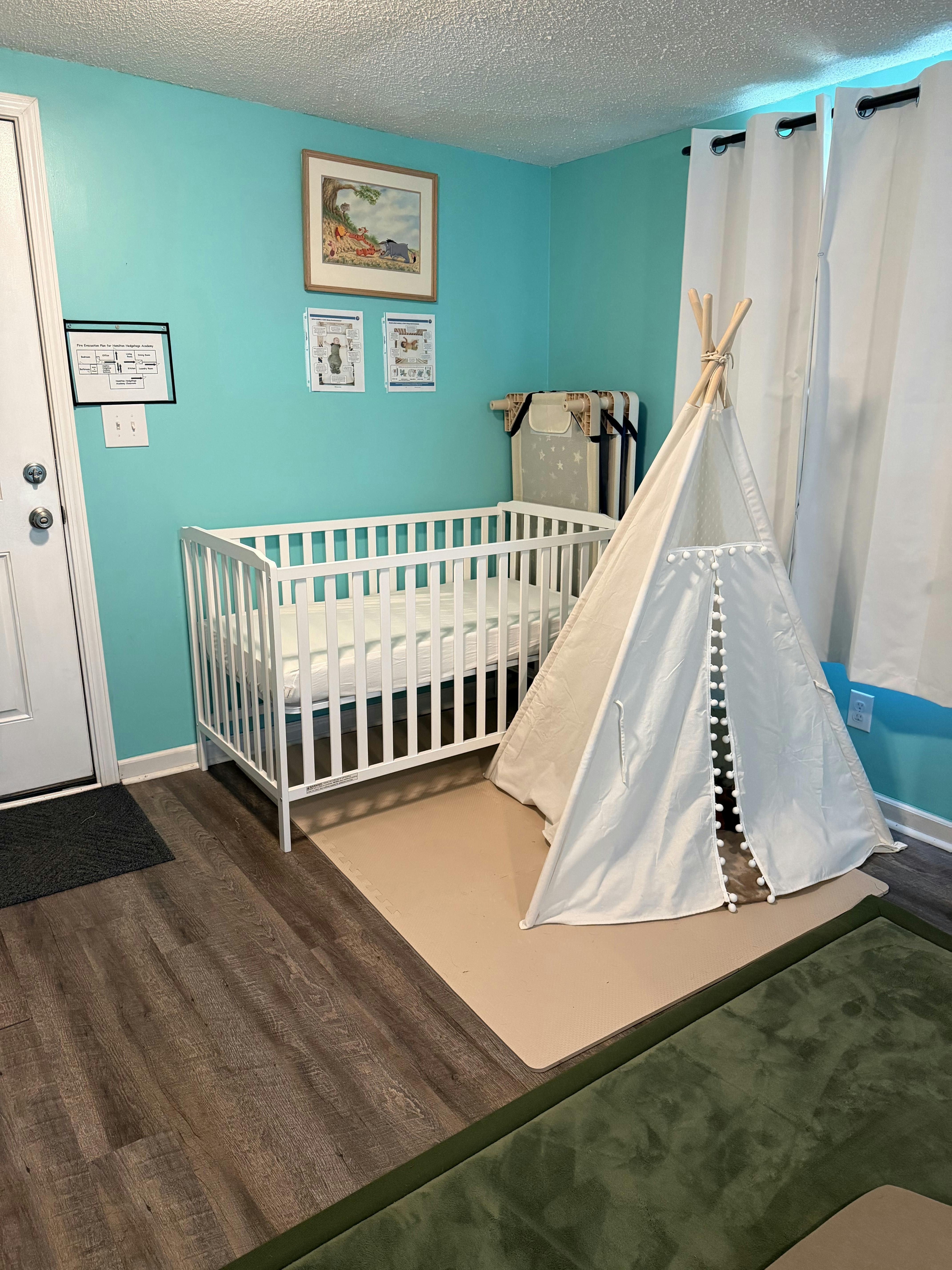 Crib and play tent in a room with turquoise walls