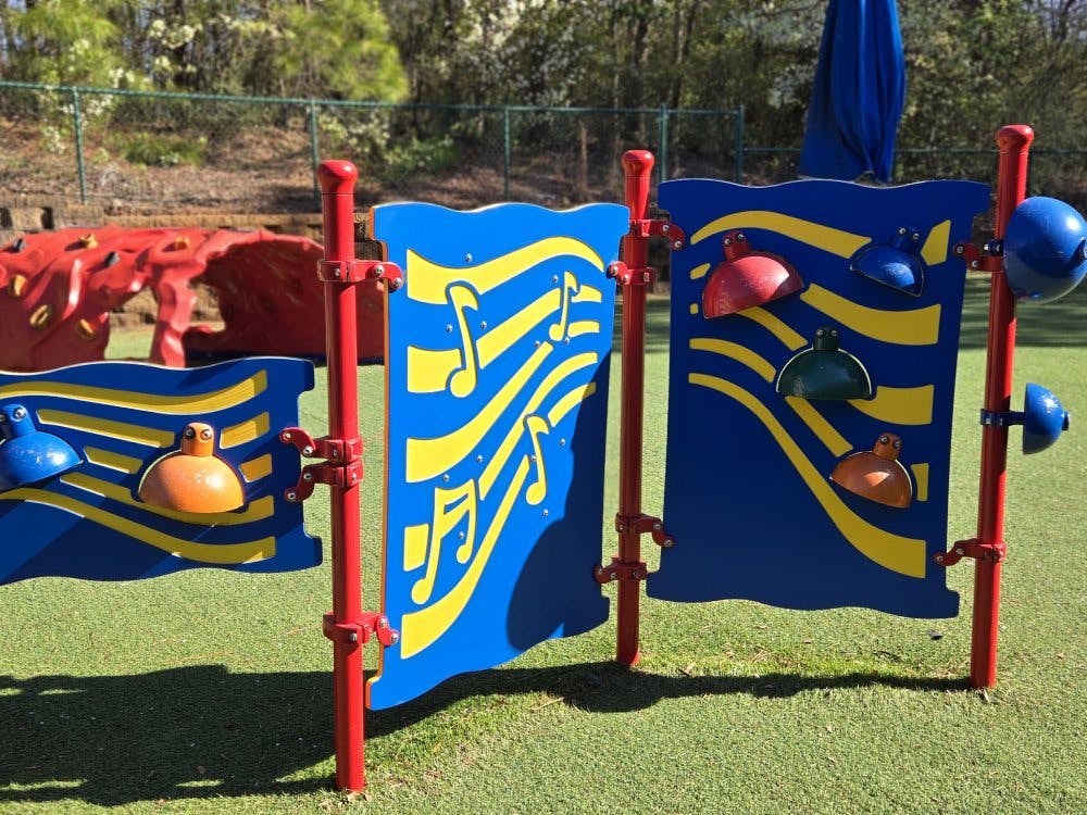 Blue and red music-themed playground panels with yellow musical notes and wavy lines