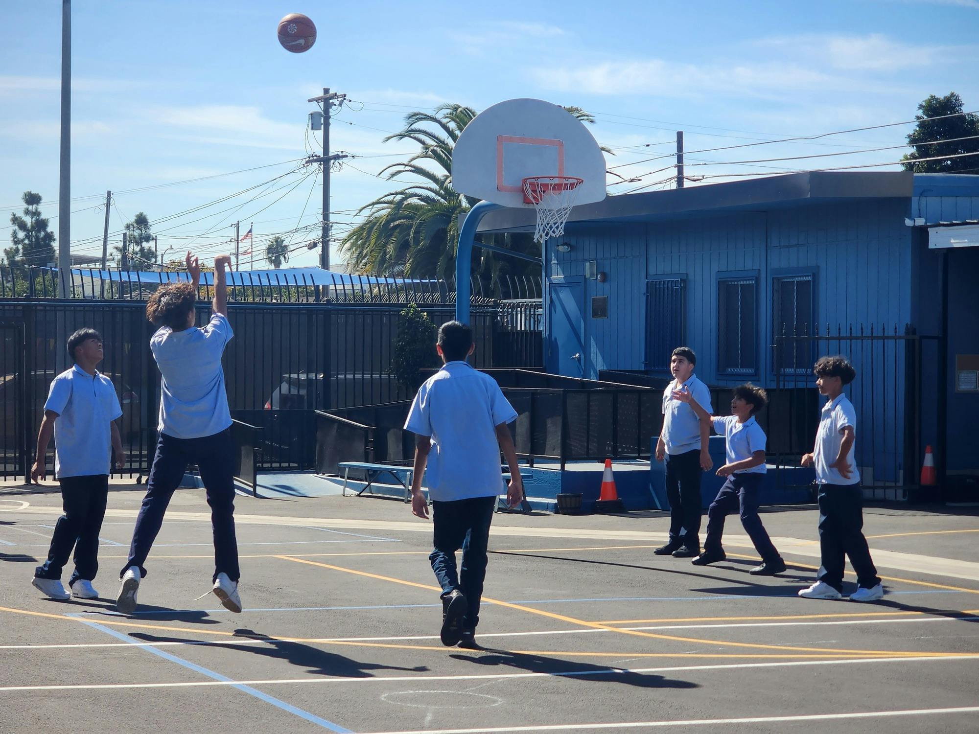 Children playing basketball on an outdoor court