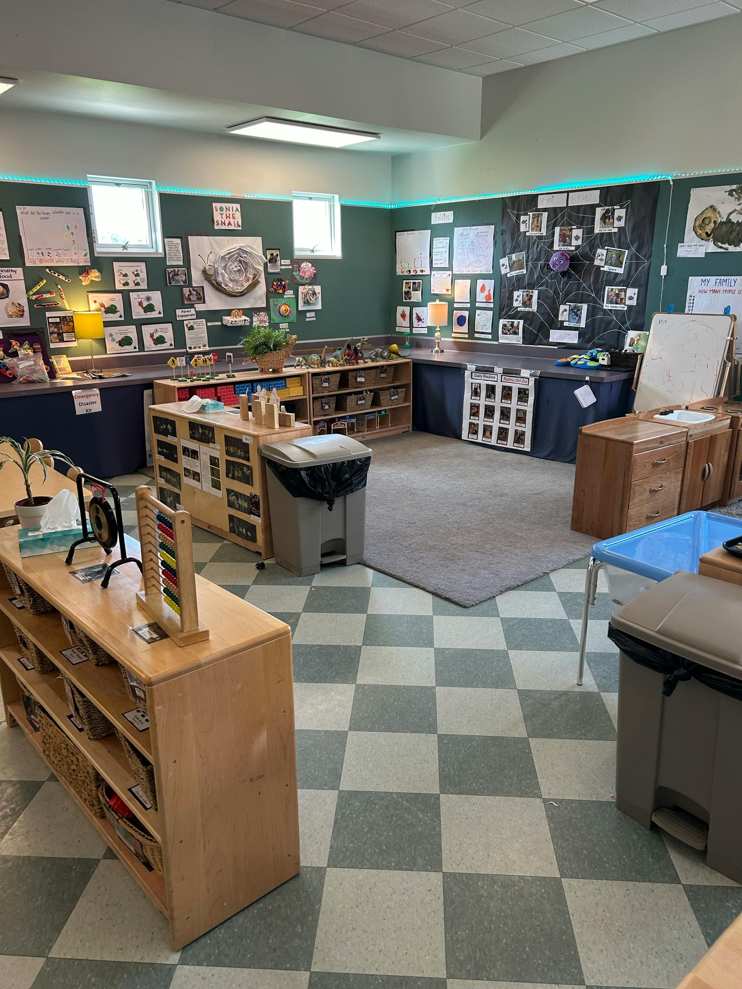 Classroom with shelves, tables, and artwork on the walls