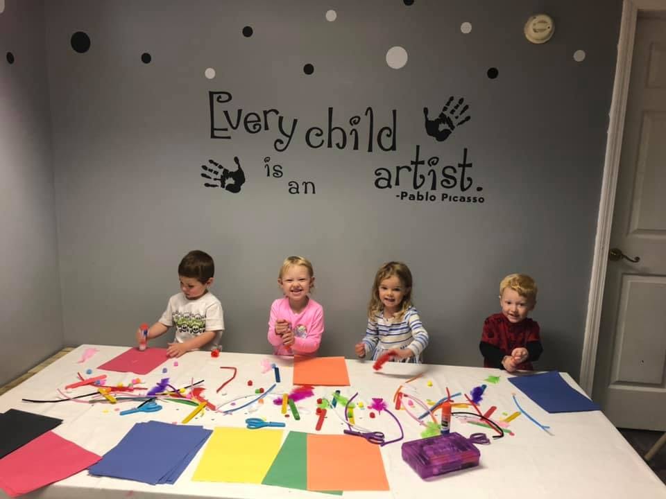 Four children at a table with art supplies