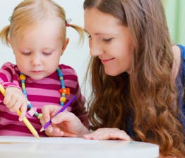 Adult and child drawing with colored pencils