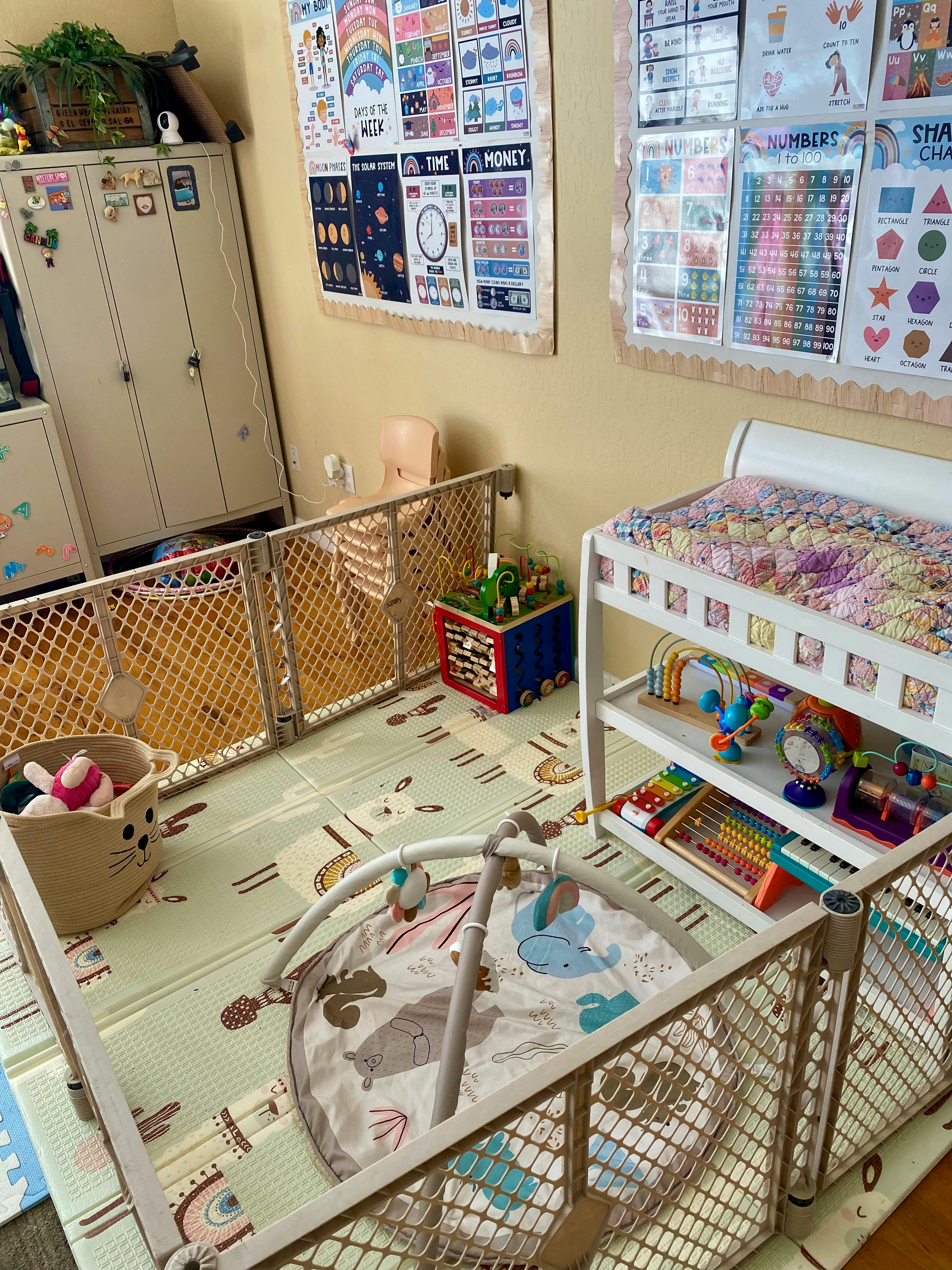 playpen with baby mat, toys, and changing table in a brightly lit room