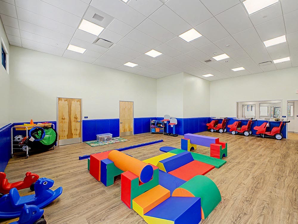 Room with colorful soft play equipment and ride-on toys