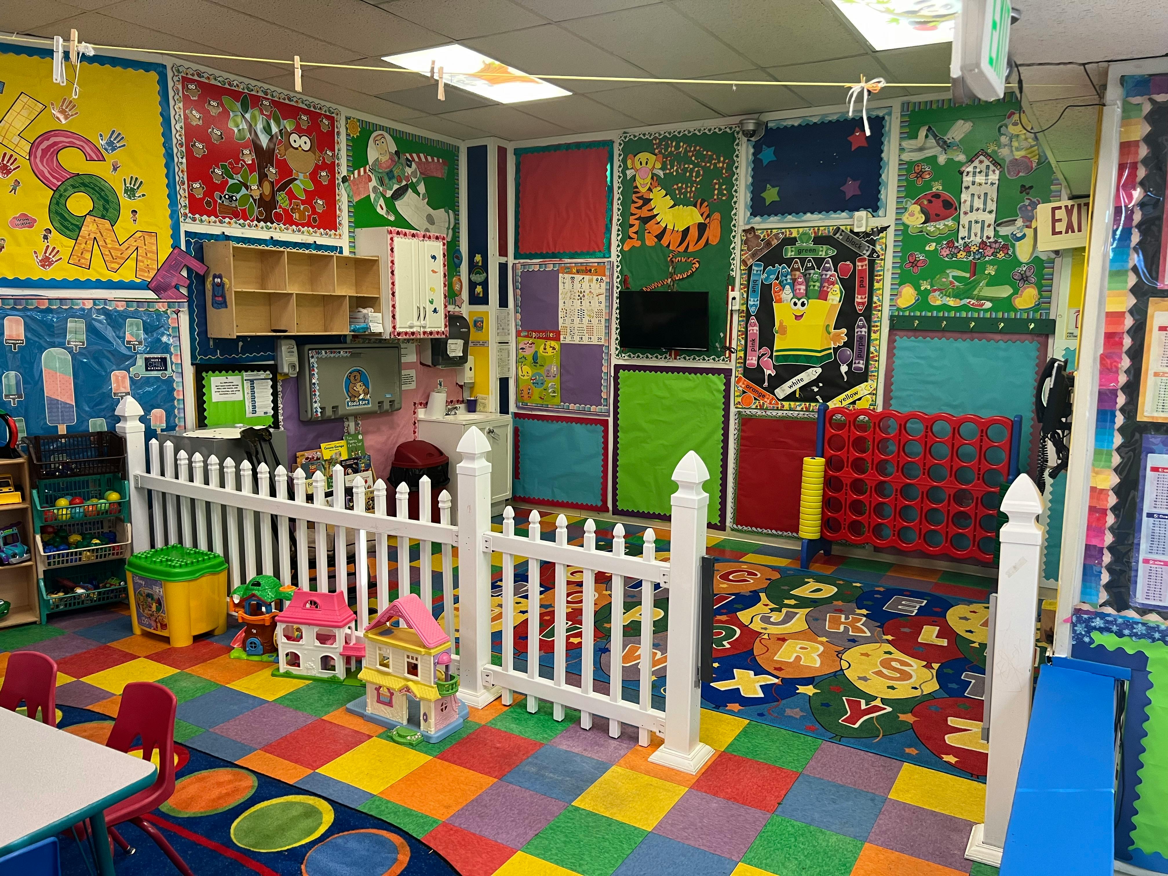 Playroom with colorful floor tiles, white fence, and wall decorations