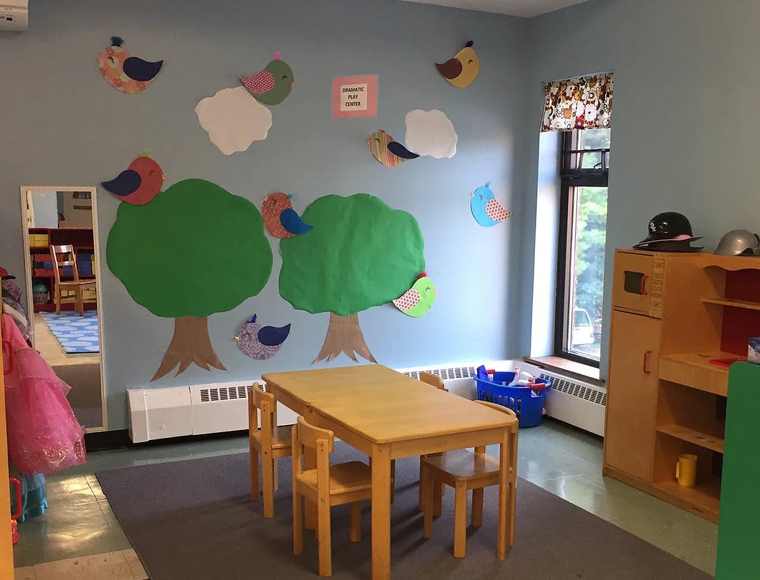 Classroom with tree and bird cutouts on the wall, table and chairs